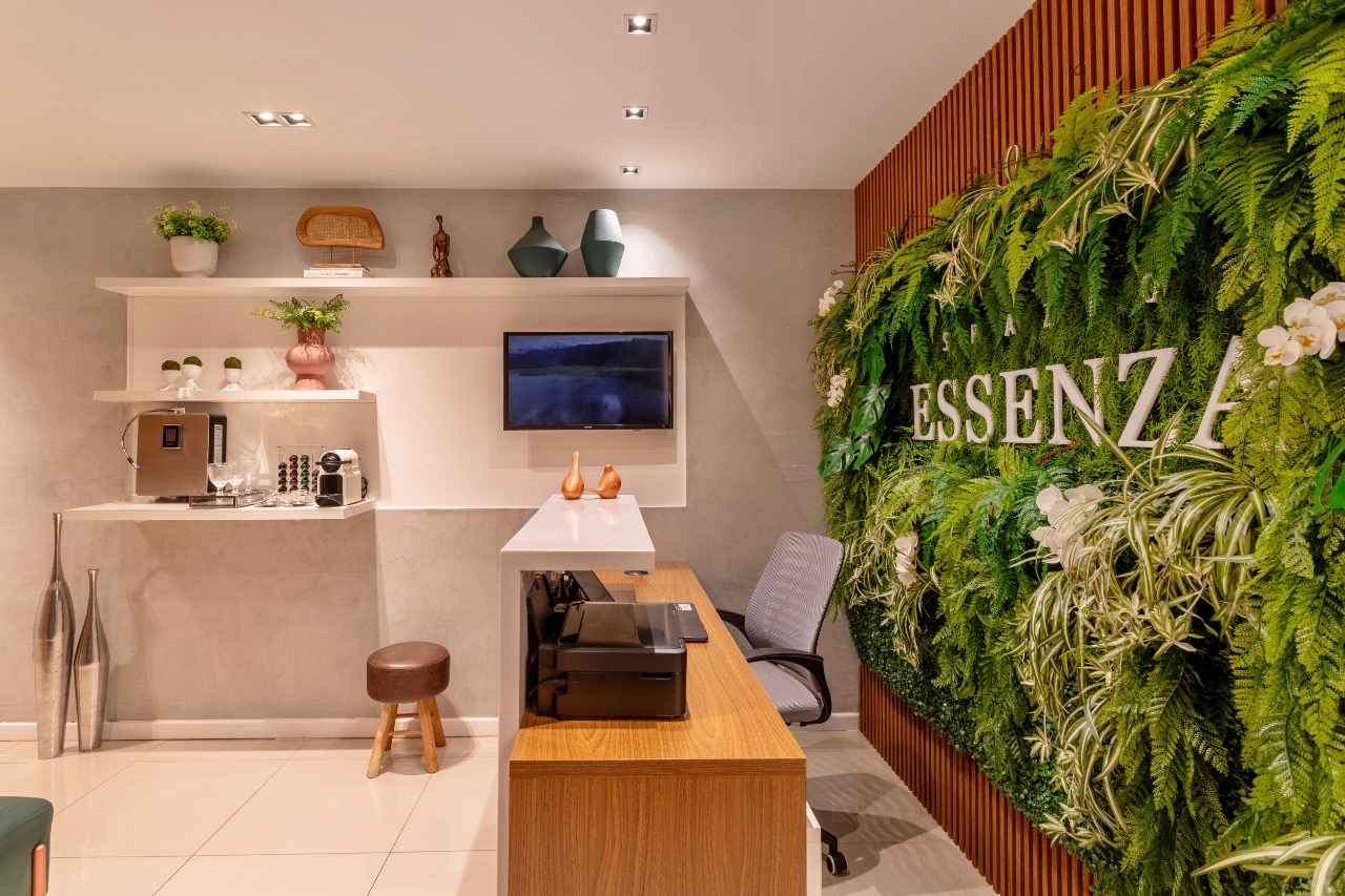 Reception area of Spazio Essenza with green wall and Essenza logo